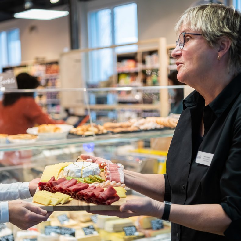Fleisch-/Käseplatte wird Kunde übergeben
